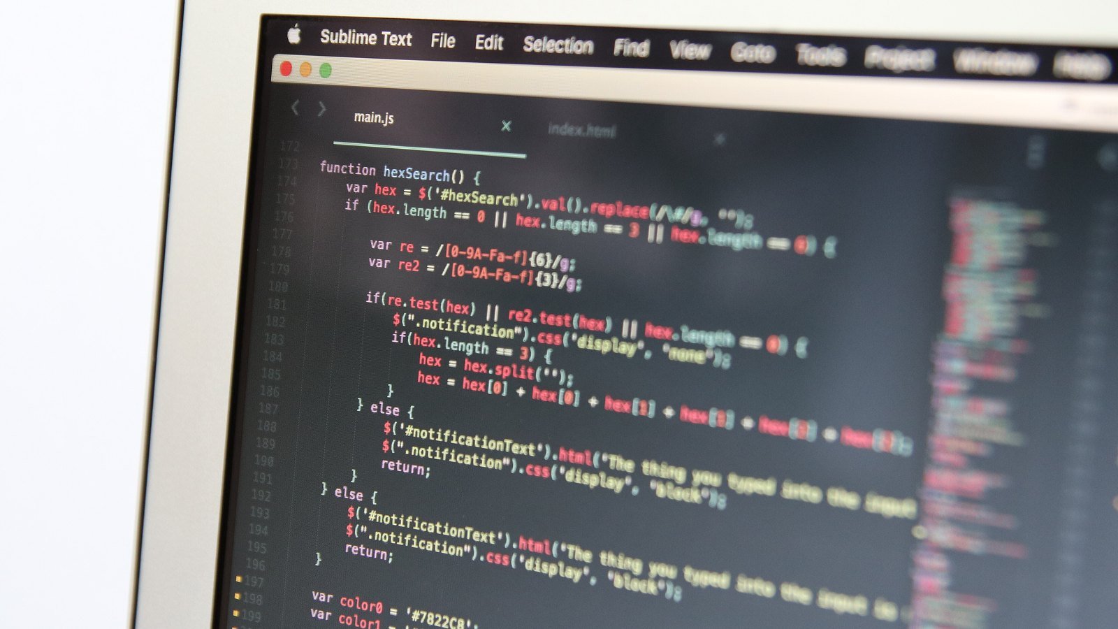 Macro shot of a laptop screen showing JavaScript code in a code editor