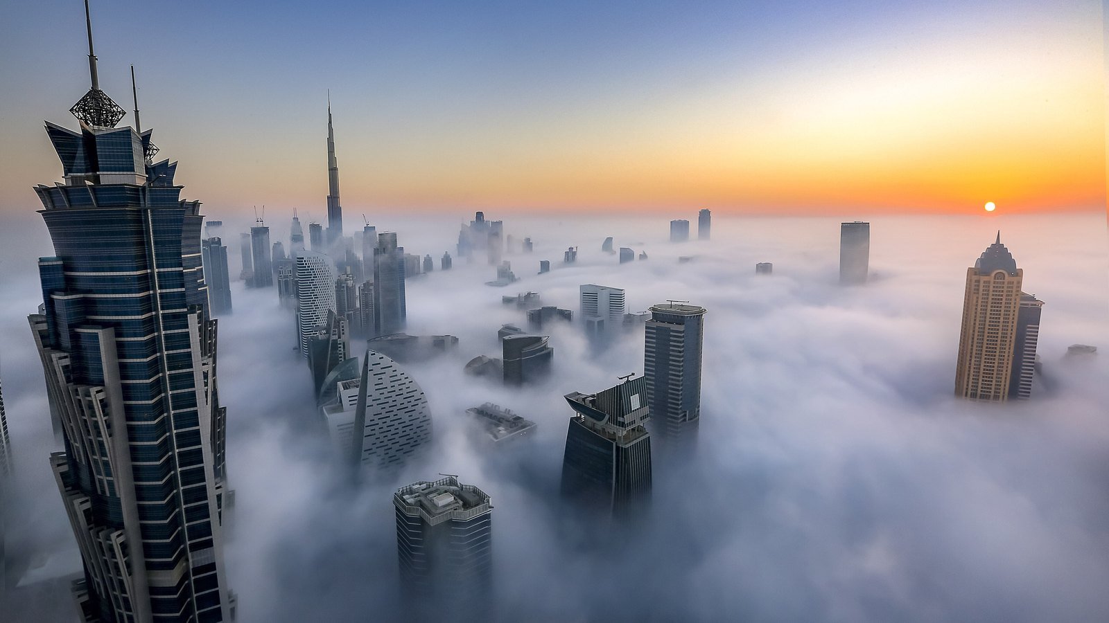 Dubai's skyscraper skyline rising above a sea of morning fog at sunrise