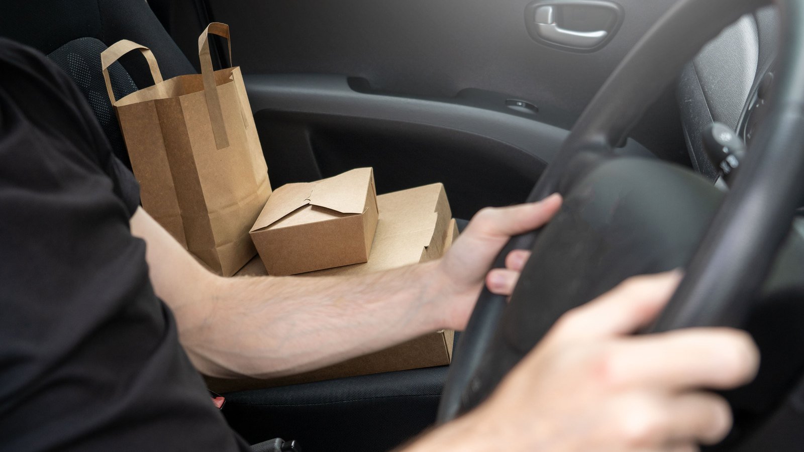Takeaway bags on the passenger seat of a delivery driver's car