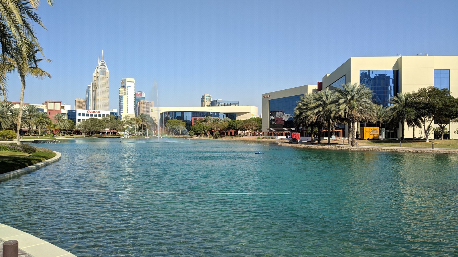 Dubai Internet City offices across the lake on a bright day